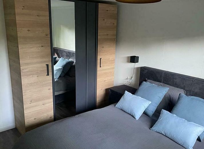 Rustic back of Cottage 54 in Wateren, Drenthe, with wooden fence and shaded area.