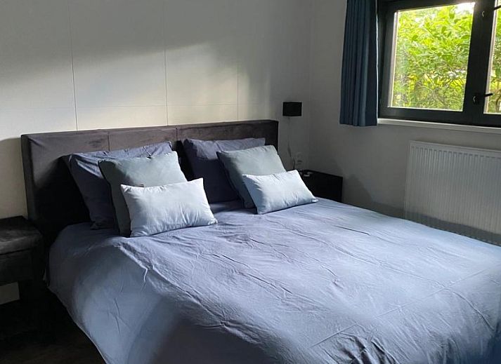 Rustic back of Cottage 54 in Wateren, Drenthe, with wooden fence and shaded area.