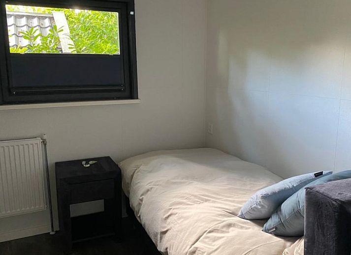 Rustic back of Cottage 54 in Wateren, Drenthe, with wooden fence and shaded area.