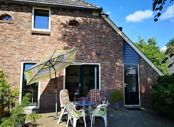 Geniet van het zonnige terras bij Vakantiehuis in Wittelte, Zuidwest Drenthe, met comfortabele stoelen en parasol.