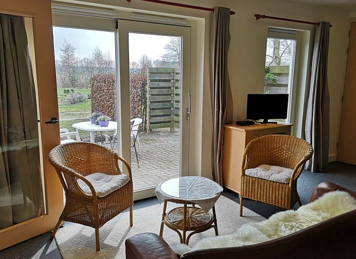 Geniet van het zonnige terras bij Vakantiehuis in Wittelte, Zuidwest Drenthe, met comfortabele stoelen en parasol.
