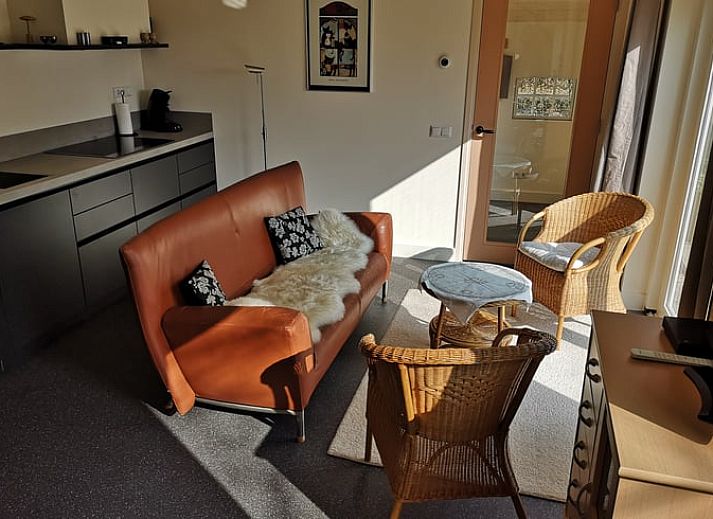 Geniet van het zonnige terras bij Vakantiehuis in Wittelte, Zuidwest Drenthe, met comfortabele stoelen en parasol.