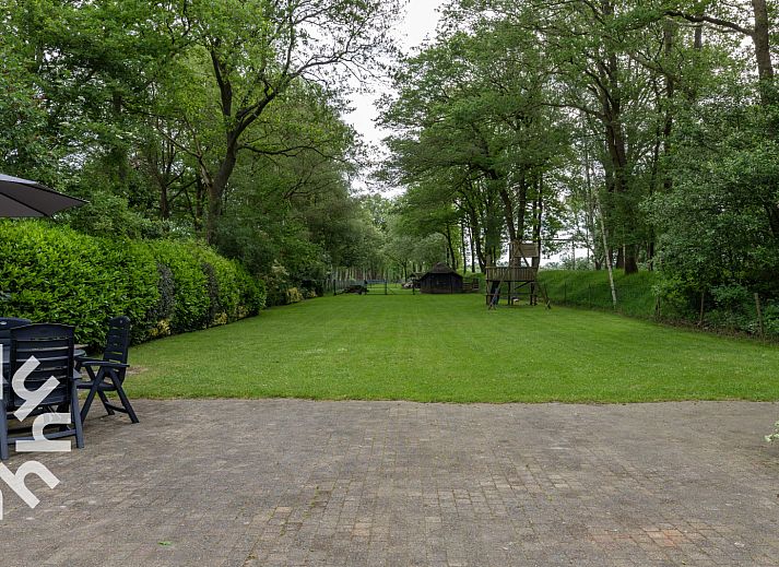 Sonnige Terrasse am Ferienhaus DG940 in Koekange, Drenthe mit Blick auf Wiesen.