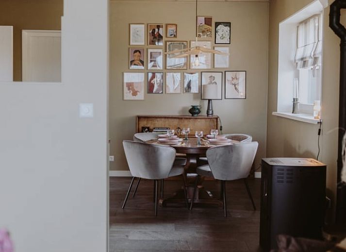 Gemuetliche Veranda im Ferienhaus in Uffelte, Suedwest-Drenthe, mit bunten Blumen und gruener Aussicht.