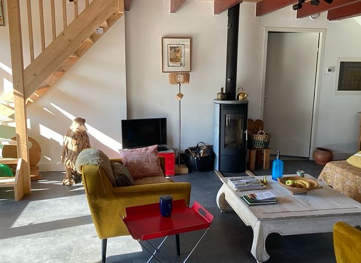 Gemuetlicher Innenraum im Ferienhaus Uffelte, Drenthe, mit kuenstlerischer Einrichtung und Holzofen.