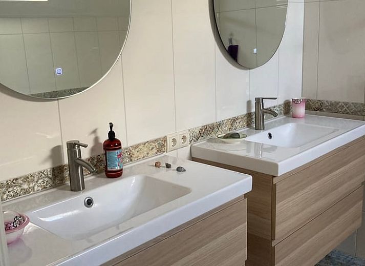 Gemuetlicher Innenraum im Ferienhaus Uffelte, Drenthe, mit kuenstlerischer Einrichtung und Holzofen.