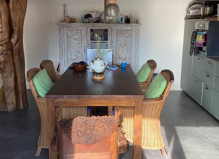 Gemuetlicher Innenraum im Ferienhaus Uffelte, Drenthe, mit kuenstlerischer Einrichtung und Holzofen.