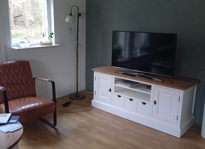 Gezellige woonkamer van Huisje in Elim, vakantiehuis in Elim, Zuidwest Drenthe met comfortabele bank en houten tafel, omgeven door natuur.