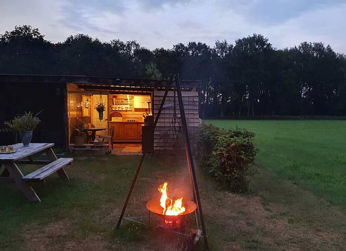 Ontspannen tuin bij Vakantiehuisje in Elim, Zuidwest Drenthe, met comfortabele stoelen en een vuurplaats.
