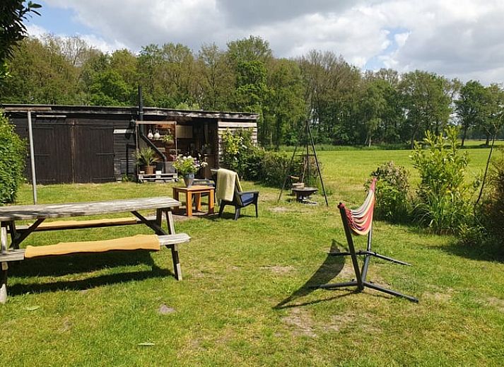 Ontspannen tuin bij Vakantiehuisje in Elim, Zuidwest Drenthe, met comfortabele stoelen en een vuurplaats.
