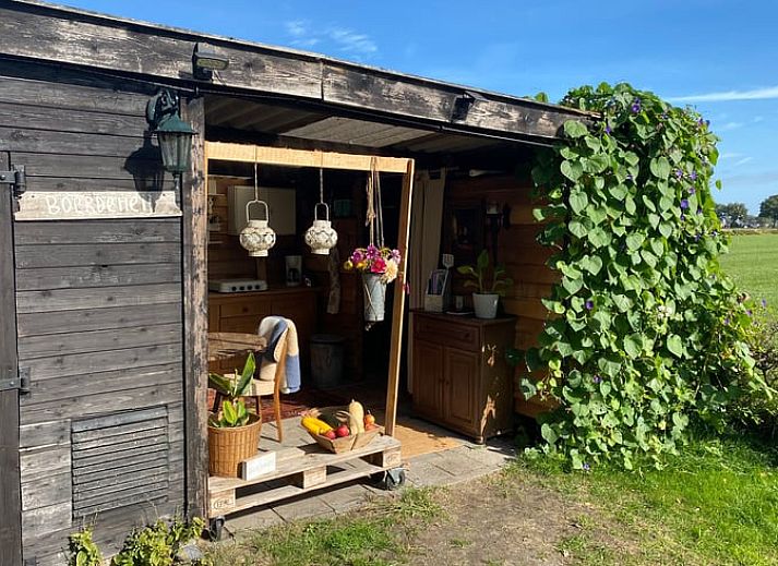 Sfeervolle avond bij Vakantiehuisje in Elim, Drenthe, met een knisperend kampvuur en open keuken.