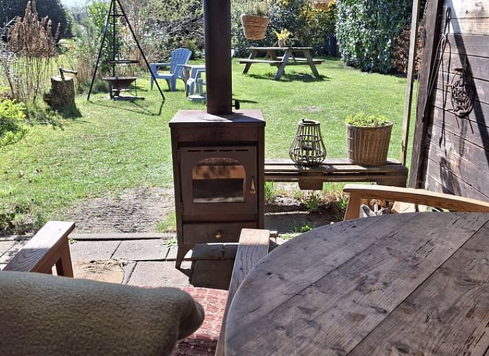 Sfeervolle avond bij Vakantiehuisje in Elim, Drenthe, met een knisperend kampvuur en open keuken.