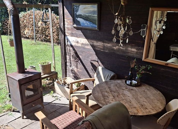 Sfeervolle avond bij Vakantiehuisje in Elim, Drenthe, met een knisperend kampvuur en open keuken.