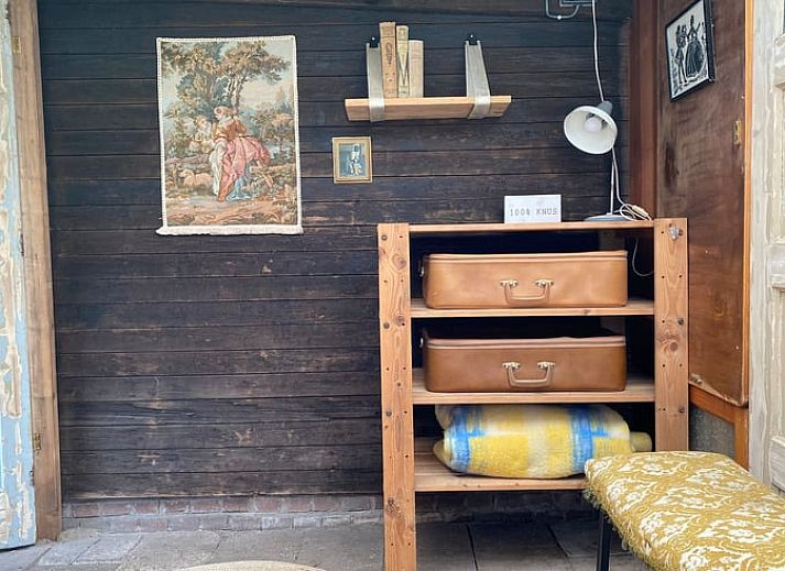 Ingang van Vakantiehuisje in Elim, Drenthe, met groene klimplanten en houten interieur.