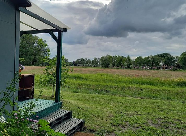 Interieur des Ferienhauses in Elim, Drenthe, mit komfortabler Einrichtung und Blick auf die Natur.