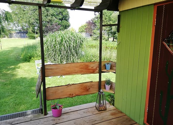 Charmante houten vakantiehuis in Elim, Drenthe, omringd door groen en rustieke picknicktafel.