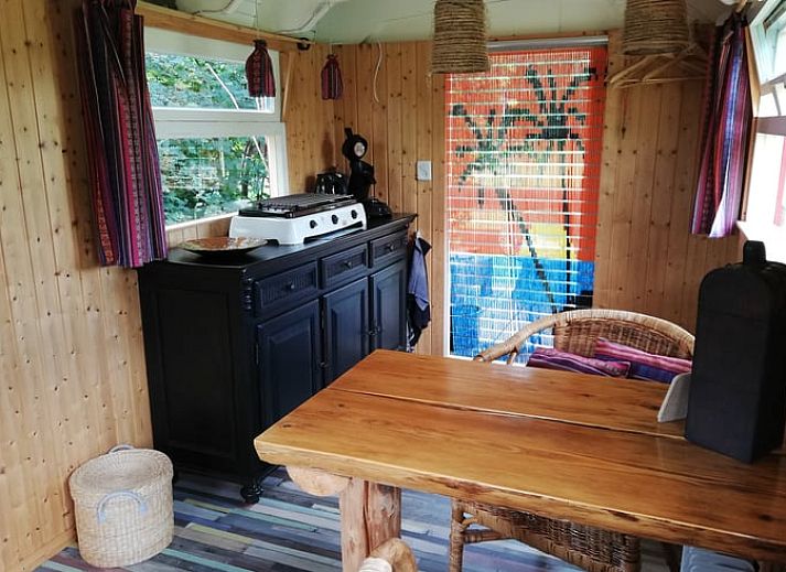 Kleurrijke veranda van vakantiehuis in Elim, Drenthe, met gezellige zitplek en bloempotten.