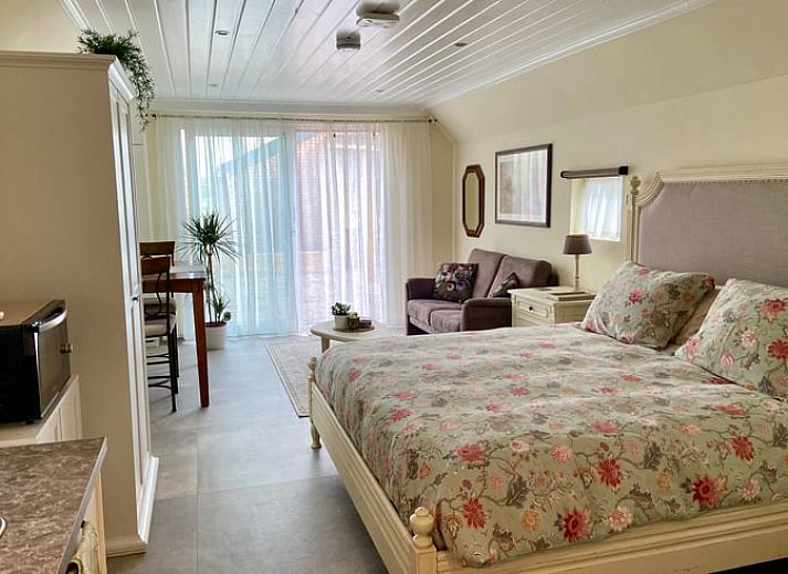 Sfeervolle slaapkamer in Huisje in Elim, vakantiehuis in Elim, Zuidwest Drenthe, met comfortabel tweepersoonsbed en toegang tot terras.