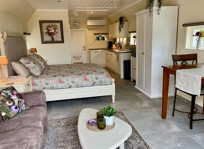 Gezellige veranda bij Huisje in Elim, vakantiehuis in Elim, Zuidwest Drenthe, met comfortabele zitplaatsen en uitzicht op groene tuin.