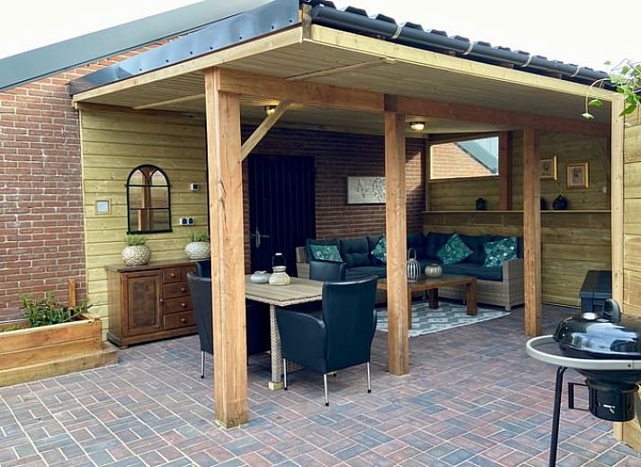 Gezellige veranda bij Huisje in Elim, vakantiehuis in Elim, Zuidwest Drenthe, met comfortabele zitplaatsen en uitzicht op groene tuin.