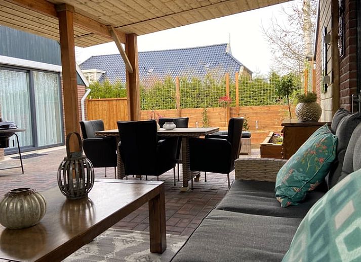 Gezellige veranda bij Huisje in Elim, vakantiehuis in Elim, Zuidwest Drenthe, met comfortabele zitplaatsen en uitzicht op groene tuin.