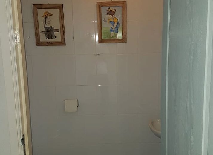 Gemuetliche Essecke im Ferienhaus in Tiendeveen, Drenthe mit Blumen und modernen Kuechengeraeten.