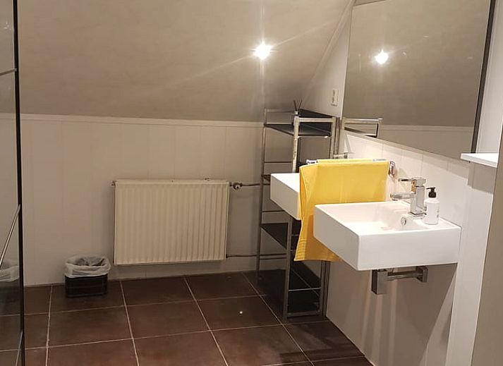 Gemuetliche Essecke im Ferienhaus in Tiendeveen, Drenthe mit Blumen und modernen Kuechengeraeten.