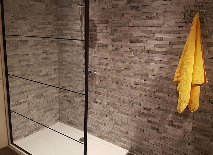 Gemuetliche Essecke im Ferienhaus in Tiendeveen, Drenthe mit Blumen und modernen Kuechengeraeten.