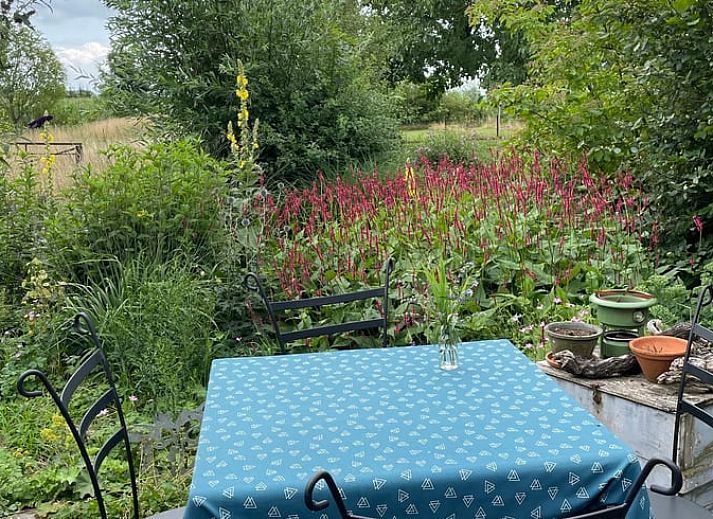 Attraktives Schlafzimmer im Ferienhaus in Nijeveen, Suedwest-Drenthe, mit Blick auf die Muehle und farbenfrohem Bettzeug.