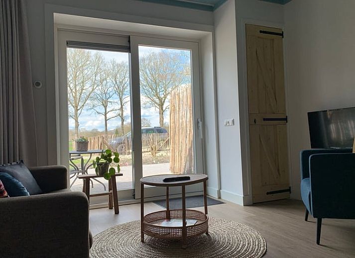 Gezellige woonkamer van Huisje in Frederiksoord, vakantiehuis in Zuidwest Drenthe met uitzicht op de natuur.