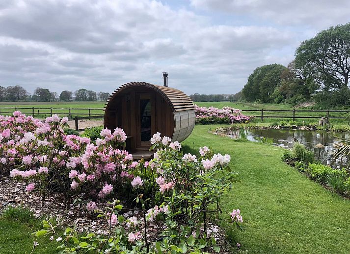 Relax in the natural surroundings of vacation home DG2027 in Dieverbrug, Drenthe, with beautiful garden views and a rustic sauna.