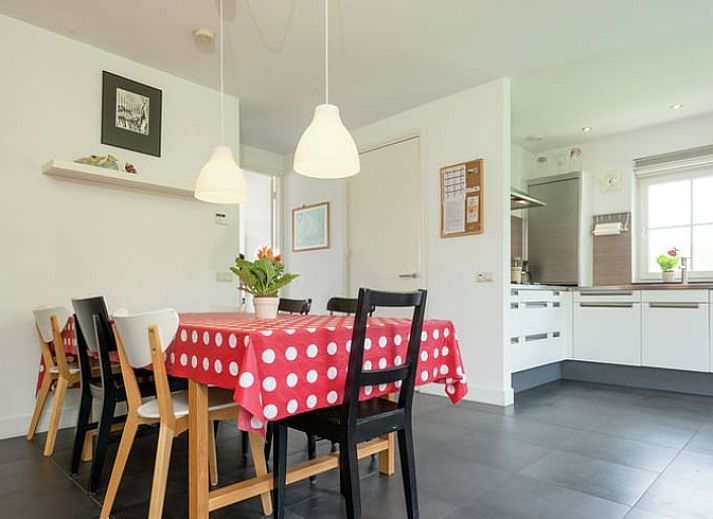 Charmante Fassade eines Ferienhauses in Hollandscheveld, umgeben von bluehenden Blumen in Drenthe.