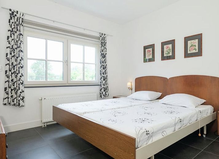 Charmante Fassade eines Ferienhauses in Hollandscheveld, umgeben von bluehenden Blumen in Drenthe.