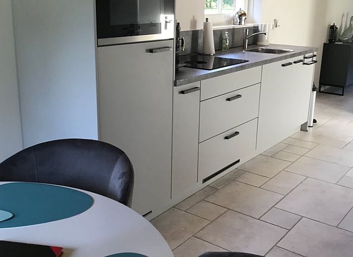 Gemuetliches Wohnzimmer mit Holzofen im Cottage in Nieuwlande, Suedwest-Drenthe.