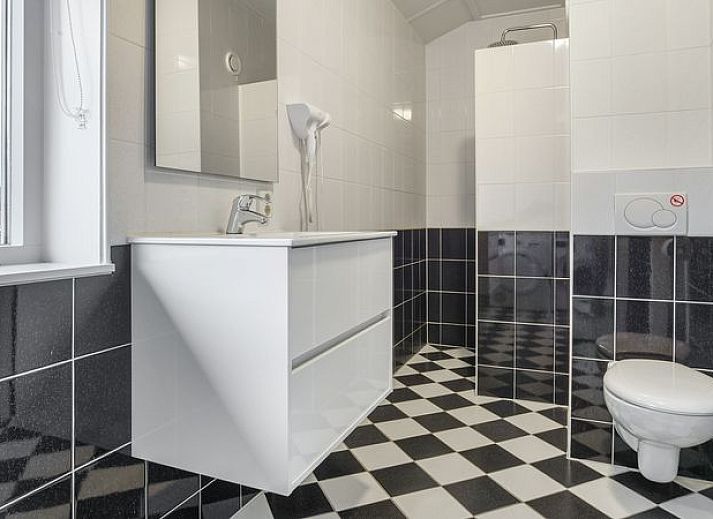 Gezellige woonkamer in Waterparc Veluwemeer bungalow met open haard en uitzicht op de tuin, Biddinghuizen.