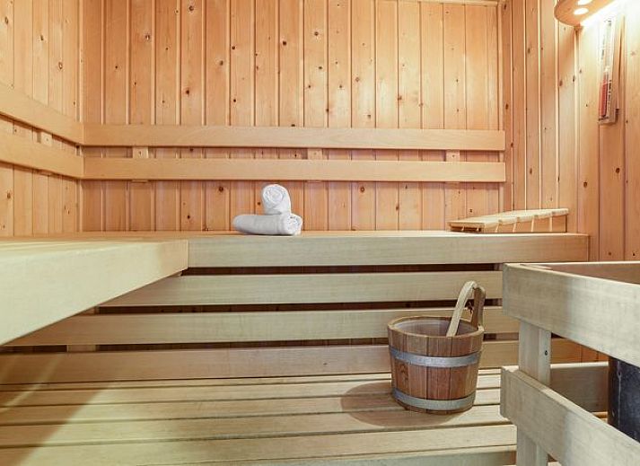 Gezellige woonkamer in Waterparc Veluwemeer bungalow met open haard en uitzicht op de tuin, Biddinghuizen.