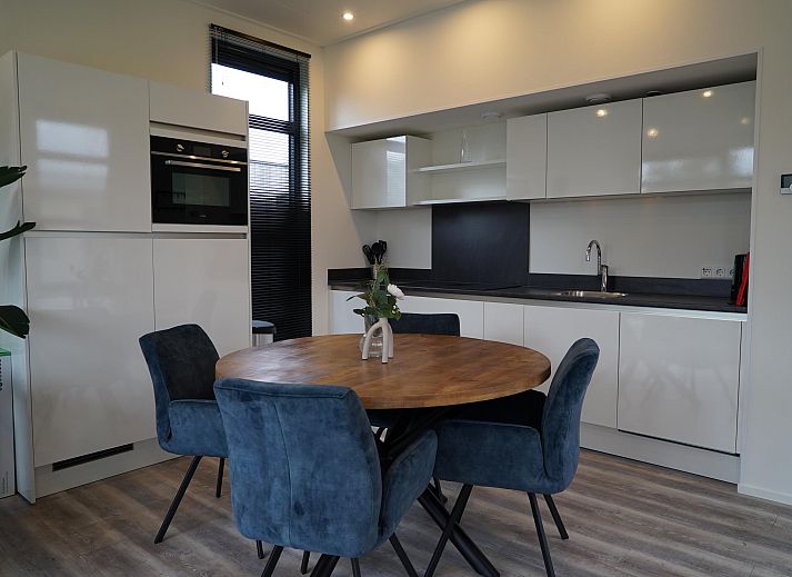Bright living room of detached house in Biddinghuizen, vacation home in Eastern Flevoland with expansive views of the green surroundings.