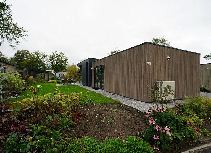 Bright living room of detached house in Biddinghuizen, vacation home in Eastern Flevoland with expansive views of the green surroundings.