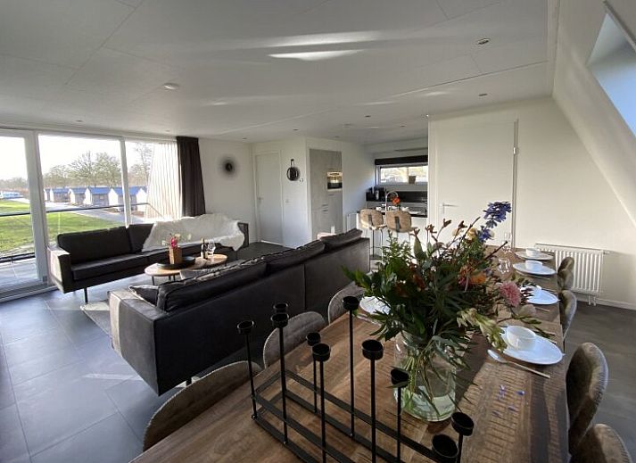 Modern living room of detached house in Biddinghuizen, vacation home in Flevoland with comfortable seating area and view of the garden.