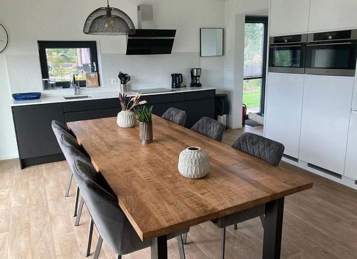 Gezellige woonkamer in Vakantiehuis Cube Elite 6, Biddinghuizen, Flevoland met moderne inrichting en uitzicht op de tuin.