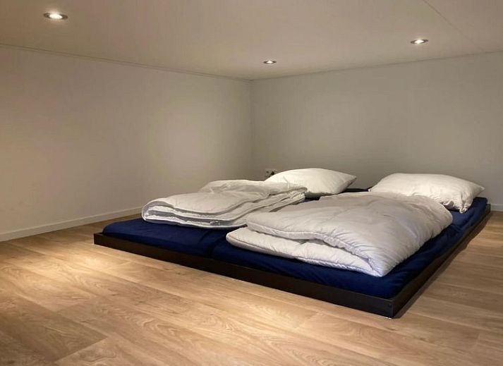 Stijlvolle eetruimte in Vakantiehuis Cube Elite 6, Biddinghuizen, Flevoland met grote houten tafel en moderne keuken.