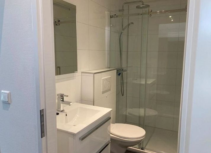 Stijlvolle eetruimte in Vakantiehuis Cube Elite 6, Biddinghuizen, Flevoland met grote houten tafel en moderne keuken.