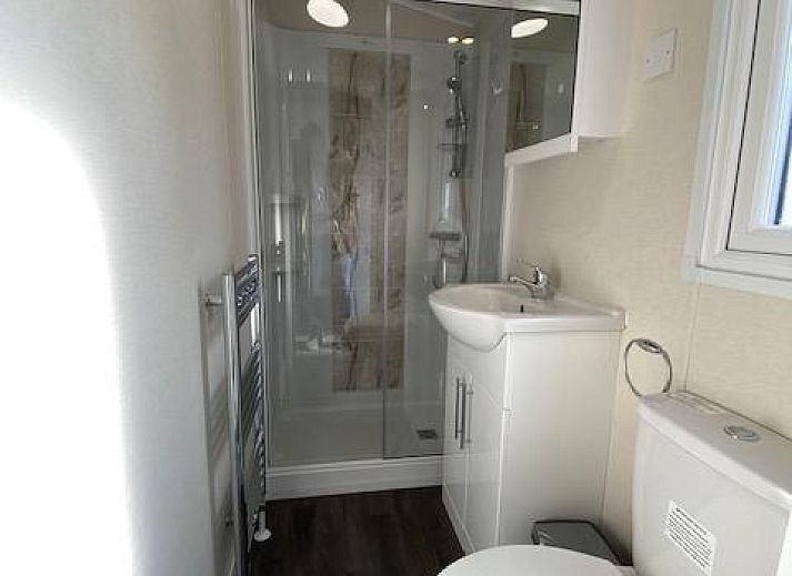 Bright living room of detached house in Biddinghuizen, Eastern Flevoland. Comfortable vacation home with modern furnishings and garden view.