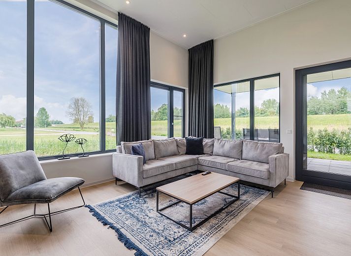 Stilvolles Wohnzimmer des Waterparc Veluwemeer Bungalows in Biddinghuizen mit Panoramablick auf die Natur.