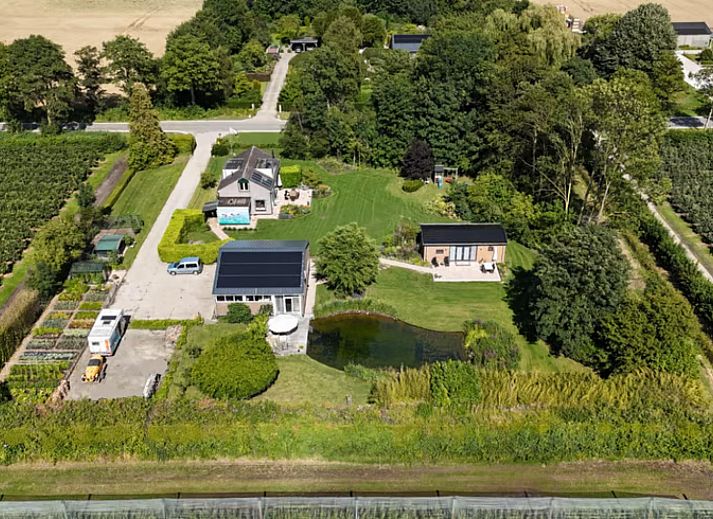 Ferienhaus FL088 in Kraggenburg, Ost-Flevoland, umgeben von ueppiger Natur und einem ruhigen Teich fuer einen entspannten Aufenthalt.