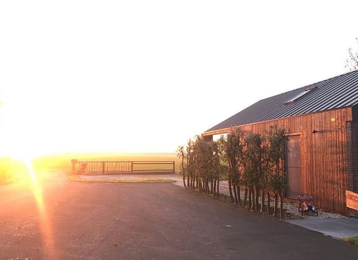 Luftaufnahme des Ferienhauses in Kraggenburg, Ost-Flevoland, mit moderner Veranda und gruener Umgebung.