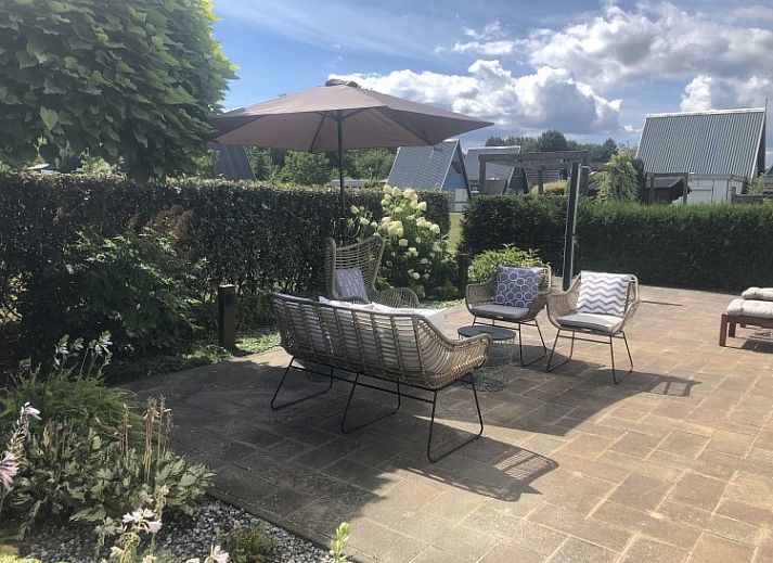 Terrace of A76 vacation home in Zeewolde, Southern Flevoland with comfortable sunbeds and seating area.