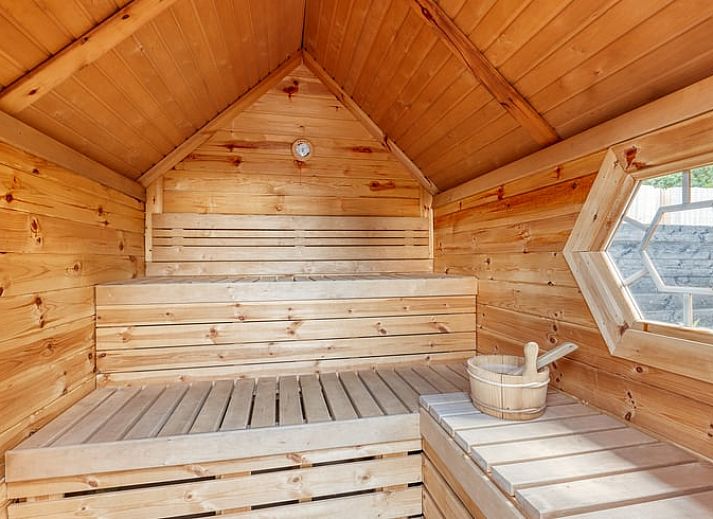 Moderne binnenruimte van Huisje in Zeewolde met houten trap en keuken, ideaal voor een comfortabel verblijf.