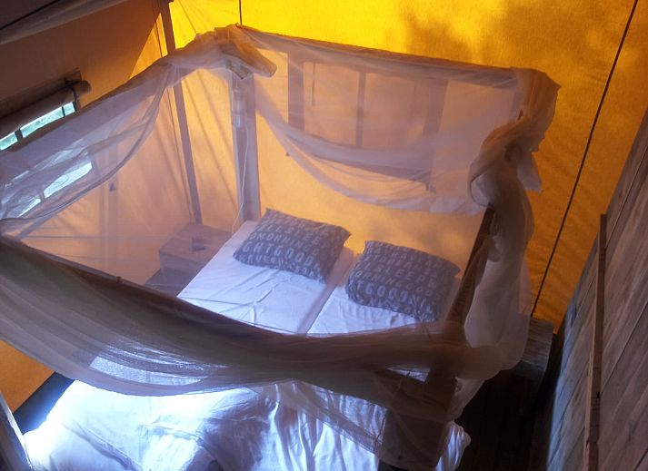 Ontspannen familie op veranda van Safaritent de Zwaluw in Zeewolde, Zuidelijk Flevoland, perfect vakantiehuis.