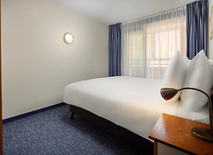 Gezellige woonkamer met uitzicht op het terras bij WestCord ApartHotel Boschrijck, West-Terschelling.